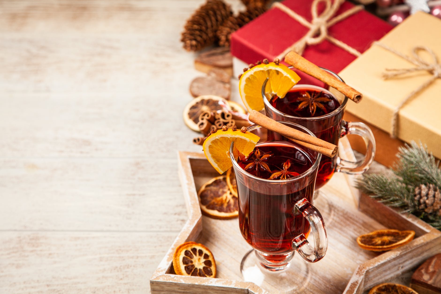Star tray holding 2 cups of holiday drinks with oranges and cinnamon sticks as garnish. 