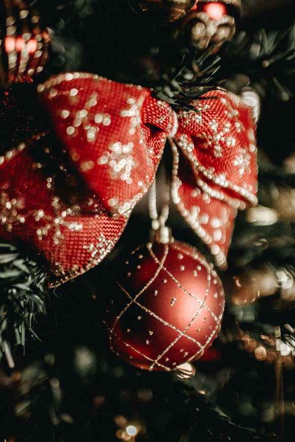 close up photo of red and gold bow and Christmas ornament